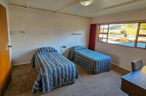 a room with two beds and a window at Discovery Countrytime Hotel in Omarama