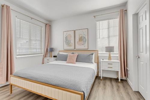 a white bedroom with a bed and two windows at Mountain View by Cloud Dream Homes in Clearfield