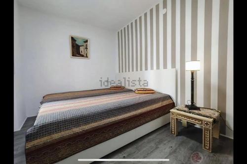a bedroom with a bed and a table with a lamp at 5 minutos hacia el mar in El Campello