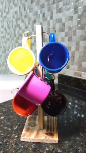 a group of different colored bowls on a wooden stand at Loft Frente ao Mar com Piscina Aquecida, Sauna Privada - Arraial do Cabo in Arraial do Cabo
