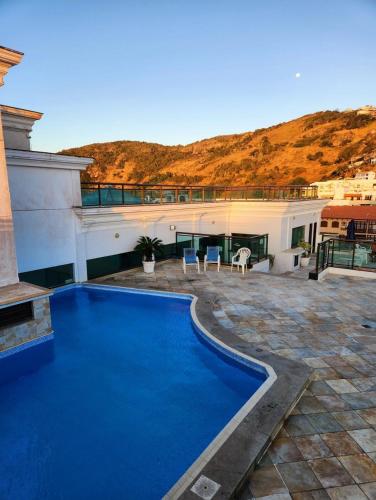 a swimming pool in front of a building at Loft Frente ao Mar com Piscina Aquecida, Sauna Privada - Arraial do Cabo in Arraial do Cabo