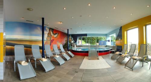 Großes Zimmer mit Pool und Stühlen in der Unterkunft Hotel Alpengasthof Hochegger in Klippitztorl