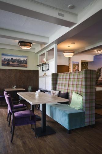 a dining room with a table and purple chairs at Egestorfer Hof in Egestorf