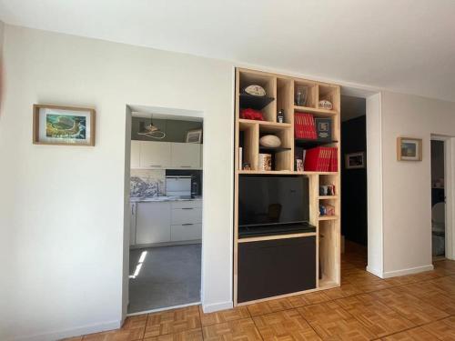 un salon avec une télévision et une cuisine dans l'établissement Évasion Crampel cosy Appartement proche centre Toulouse, à Toulouse
