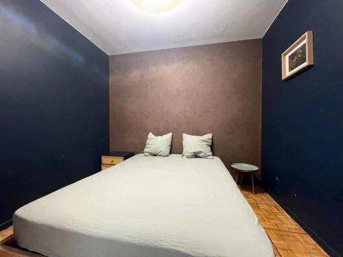 - une chambre avec un grand lit blanc et un mur bleu dans l'établissement Évasion Crampel cosy Appartement proche centre Toulouse, à Toulouse