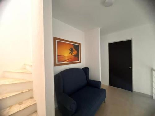 a blue chair in a room with a picture on the wall at Residencial Terrasol Villa 342 in Acapulco