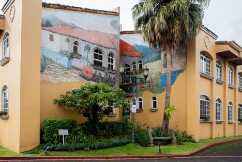 a mural on the side of a building with a palm tree at Casa Conde Hotel & Apartamentos in San José