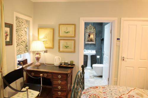 a room with a desk and a bathroom with a sink at Luxor House in London