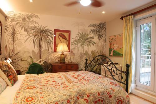 a bedroom with a bed with a tropical wallpaper at Luxor House in London