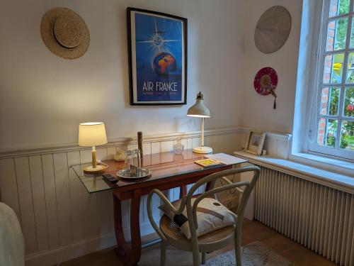 un bureau avec une lampe et une chaise dans une pièce dans l'établissement Chaleureuse chambre double avec accès jardin, WiFi et animaux admis - FR-1-590-490, à Presnoy