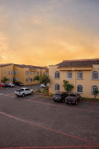 a parking lot with cars parked in front of a motel at Casa Conde Hotel & Apartamentos in San José