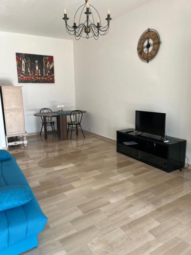 un salon avec un canapé bleu et une télévision dans l'établissement Grand studio à 2mn du port et 40mn des pistes de ski, à Nice