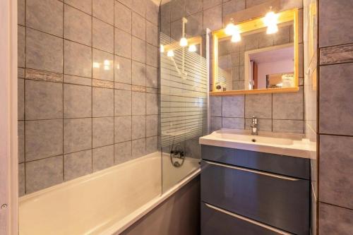 une salle de bain avec un lavabo, une baignoire et un miroir dans l'établissement Résidence Le Cervin - Résidence LE CERVIN N°201 MAE-4991, à La Plagne Tarentaise