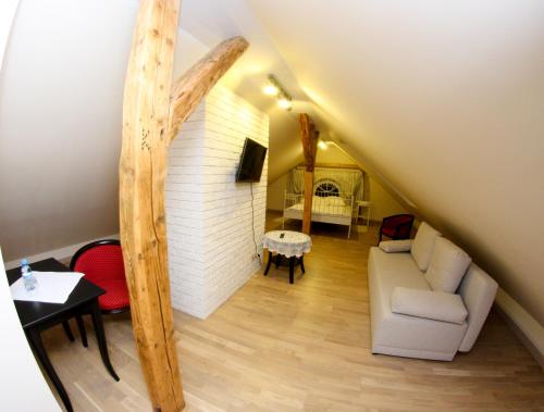 a room with a staircase with a couch and a table at Mazurski Dwór in Olecko