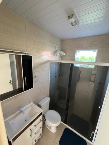 a bathroom with a shower and a toilet and a sink at Refúgio da Camboa - Casa Menta in Governador Celso Ramos