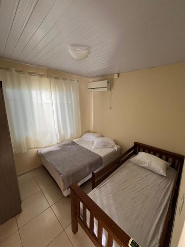 ein Schlafzimmer mit zwei Betten und einem Fenster in der Unterkunft Refúgio da Camboa - Casa Menta in Governador Celso Ramos