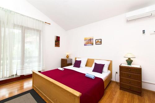 a bedroom with a large bed and a window at Apartments Neva in Sumpetar