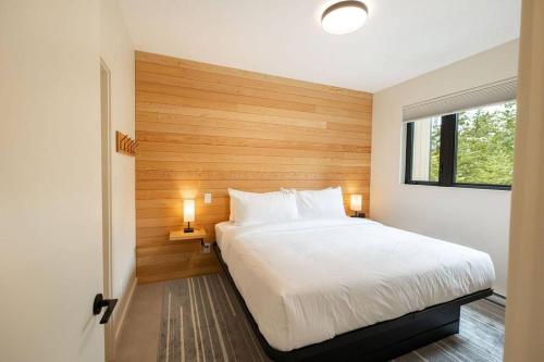 a bedroom with a large white bed and a window at Calmwater Retreat New 2 br Hot Tub in Ucluelet