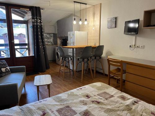 Cette chambre comprend une cuisine, une table et des chaises. dans l'établissement Studio rénové 27m² avec balcon, wifi et parking - 4 pers., animaux admis - FR-1-512-283, à Brides-les-Bains