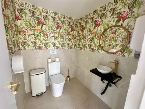 a bathroom with a sink and a toilet and a mirror at Palm Garden Valencia in Bétera