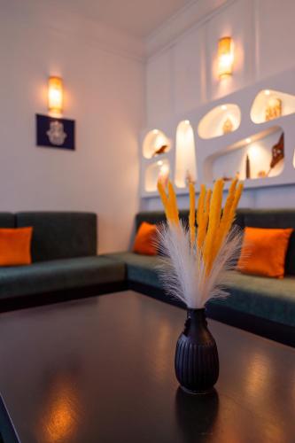 a living room with a vase on a coffee table at Riad L'ECOLE in Marrakech