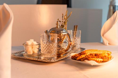 a table with a tea kettle and a plate of food at Riad L'ECOLE in Marrakech