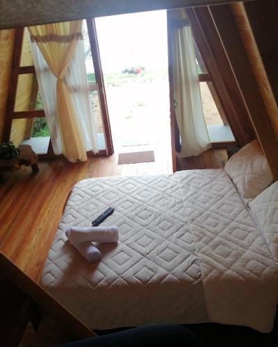a bed in a room with a large window at Cabañas Alpina in San Agustín