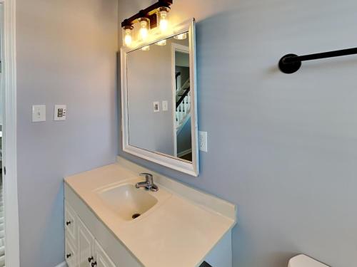 a bathroom with a sink and a mirror at Sea Chase in Topsail Beach