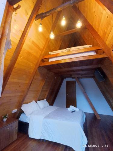 a attic room with two beds and a loft at Cabañas Alpina in San Agustín