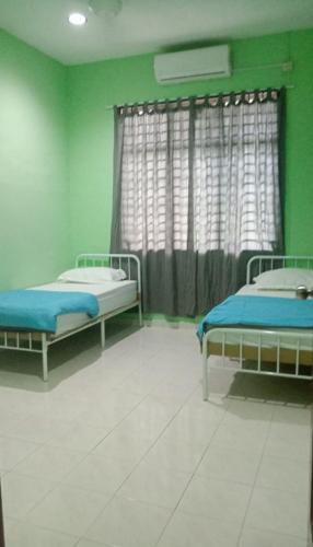 a hospital room with two beds and a window at Homestay Taman Delima Paka in Kampong Gong Gemia