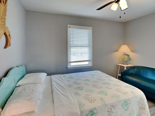 a bedroom with a bed and a blue couch at Sea Chase in Topsail Beach