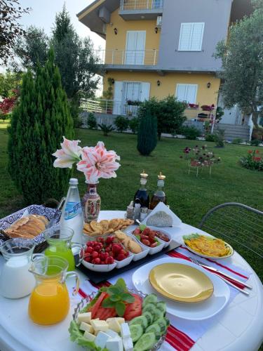 a white table with food and drinks and fruit on it at Hotel Villa Linda in Shkodër