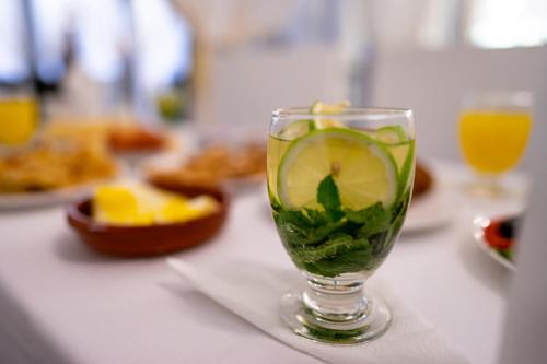 a drink in a glass on a table with orange juice at Riad L'ECOLE in Marrakech