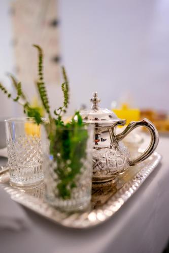 a tray with a tea pot and glasses on a table at Riad L'ECOLE in Marrakech