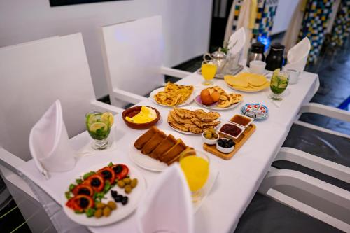 a white table with food and drinks on it at Riad L'ECOLE in Marrakech
