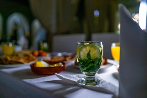 a glass with a lime in it sitting on a table at Riad L'ECOLE in Marrakech