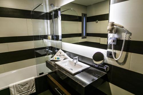 a bathroom with a sink and a mirror at Urban Central Suites - Beirut in Beirut