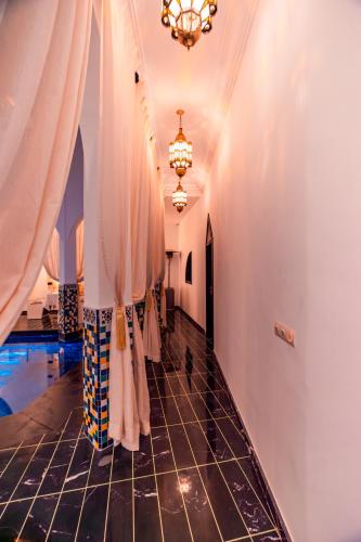 a room with a pool and a chandelier at Riad L'ECOLE in Marrakech