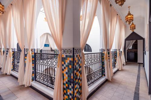 a balcony with curtains in a room at Riad L'ECOLE in Marrakech