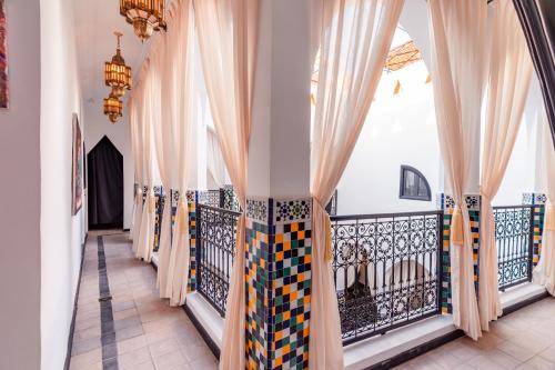 a corridor with curtains and a balcony at Riad L'ECOLE in Marrakech