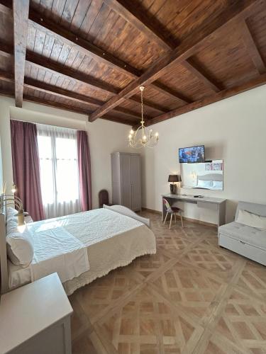 a bedroom with a large bed and a desk at Case Vacanze Al Duomo in Licata