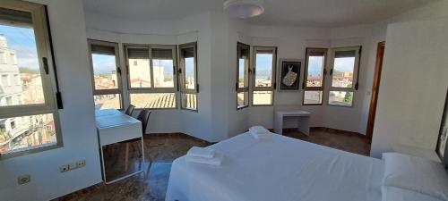 a room with two beds and windows in a building at Edificio Primavera Viviendas turísticas in Calasparra
