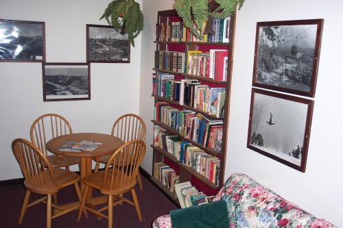 a room with a table and a book shelf filled with books at Cascades Lodge in Killington