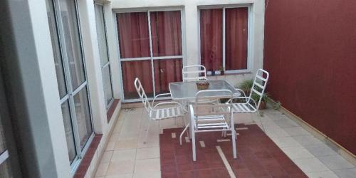 a table and chairs on a balcony with windows at charly in San Luis