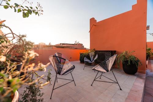 three chairs sitting on top of a patio at Riad L'ECOLE in Marrakech