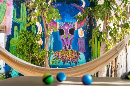 a hammock in front of a painting of a cow at Peace Hostel MX in La Paz