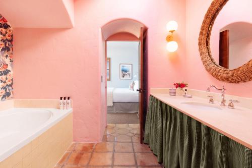 a bathroom with a tub and a sink and a mirror at Palihouse Santa Barbara in Santa Barbara