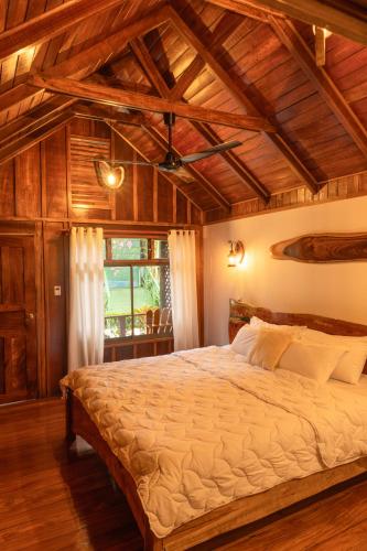 a bedroom with a large bed in a room with wooden ceilings at La Fortuna Natural Green in Fortuna