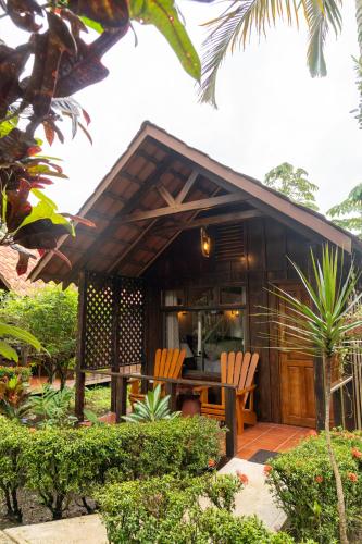 a house with two chairs and a table in front of it at La Fortuna Natural Green in Fortuna