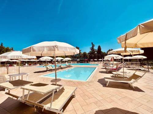 una piscina con lettini e ombrelloni di Flora Apt -100m dal Lago di Garda - Piscina a Sirmione